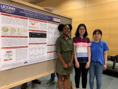 Lab members in front of a bulletin board
