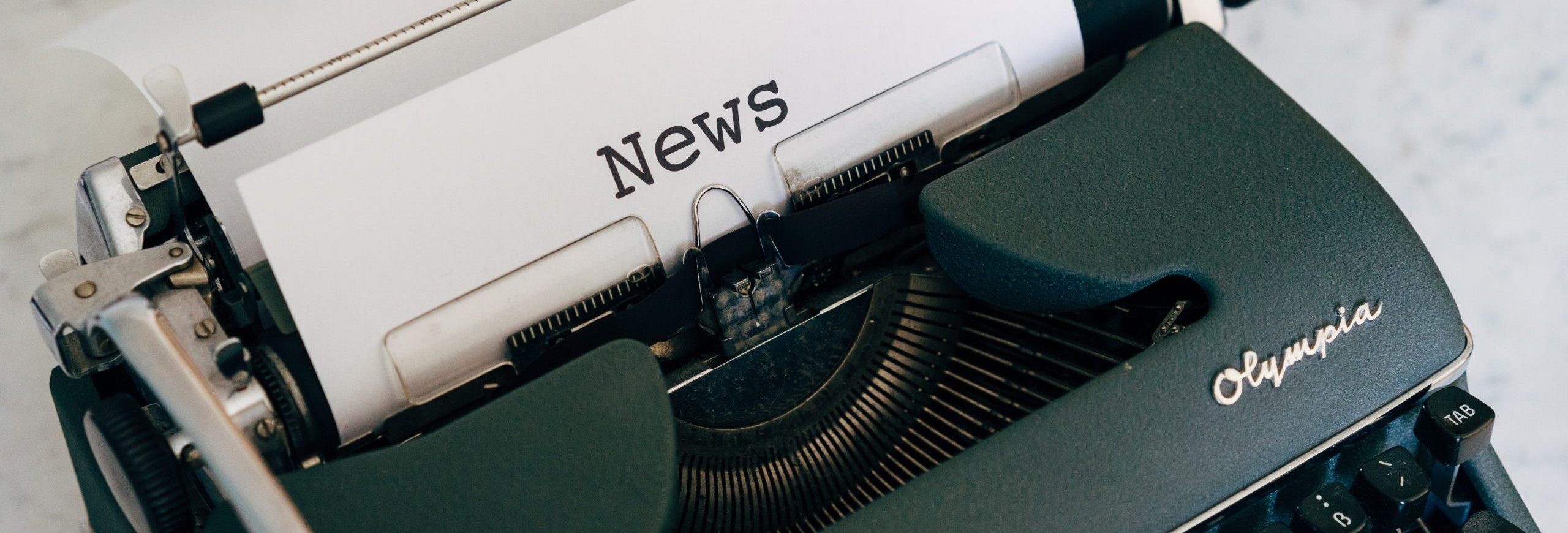 typewriter with paper and word news on it